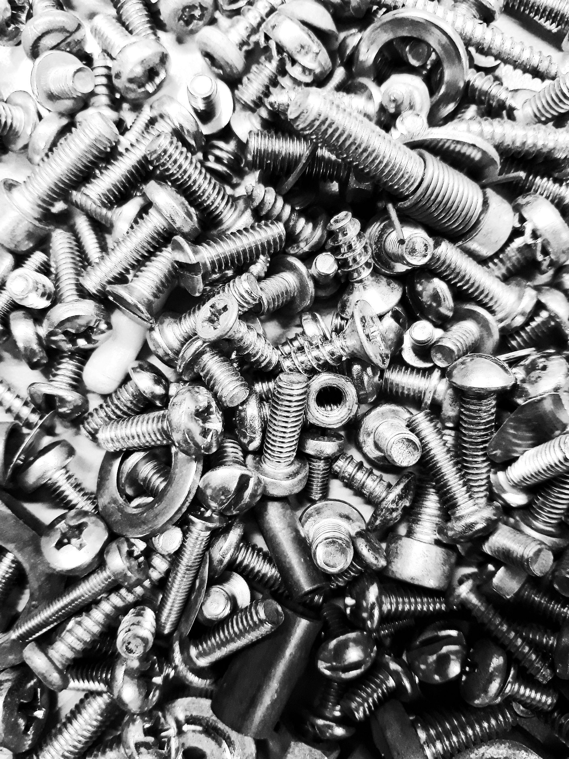 Close up of stainless steel butterfly bolts and wing nuts on a workbench